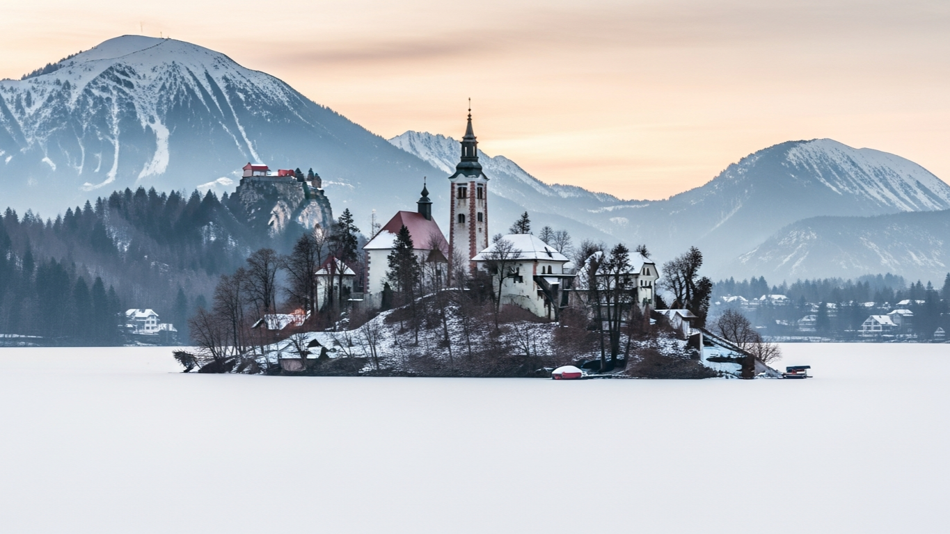 Lake Bled ในฤดูหนาวทะเลสาบแข็งตัวทั้งผืน มองเห็น Bled Island ปกคลุมด้วยหิมะ